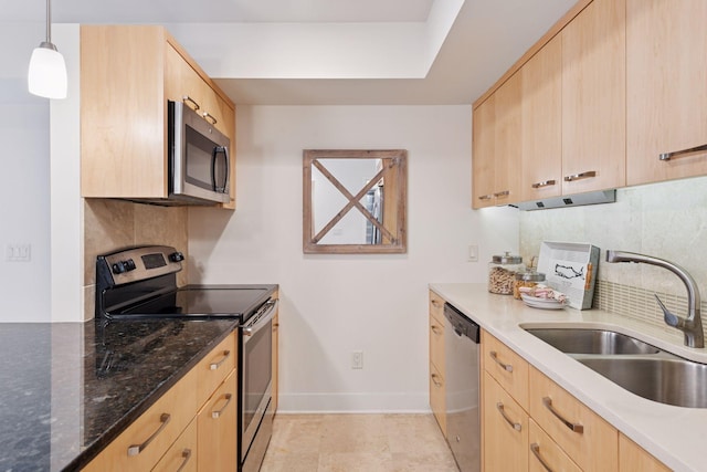 kitchen with light brown cabinets, tasteful backsplash, appliances with stainless steel finishes, and a sink