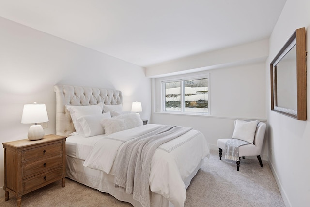 bedroom with baseboards and light carpet