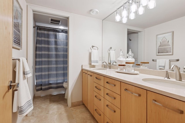 full bath featuring double vanity, visible vents, toilet, and a sink