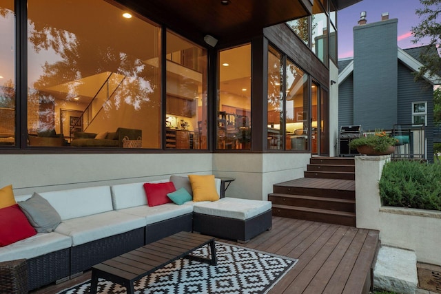 deck at dusk with outdoor lounge area and a grill