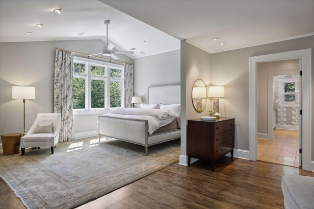 bedroom with hardwood / wood-style flooring, ceiling fan, crown molding, and vaulted ceiling