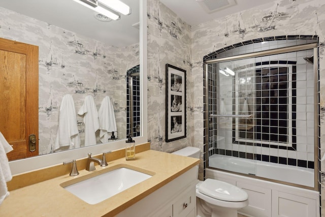 full bathroom with vanity, combined bath / shower with glass door, and toilet