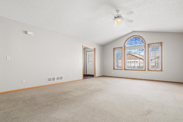 unfurnished room with ceiling fan, lofted ceiling, light colored carpet, and a textured ceiling