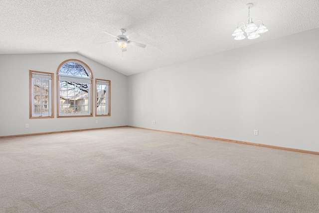 empty room with ceiling fan with notable chandelier, vaulted ceiling, light carpet, and a textured ceiling