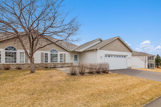 101 Bridgewater Trl, Hudson, WI 54016 - ranch-style house featuring asphalt driveway, an attached garage, a front lawn, stone siding, and a shingled roof