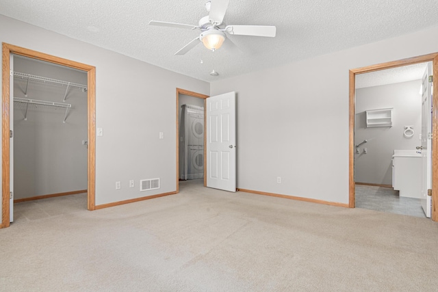 101 Bridgewater Trl, Hudson, WI 54016 - unfurnished bedroom with stacked washer / dryer, a walk in closet, carpet, a closet, and baseboards