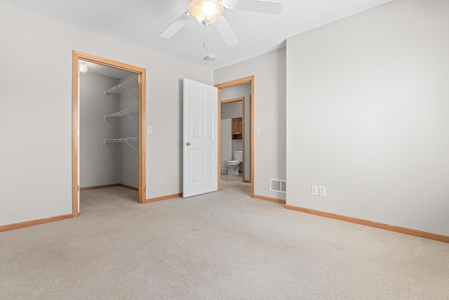 101 Bridgewater Trl, Hudson, WI 54016 - unfurnished bedroom featuring carpet, baseboards, a spacious closet, and a textured ceiling