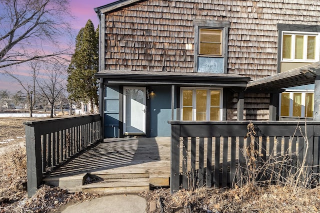 back house at dusk with a deck