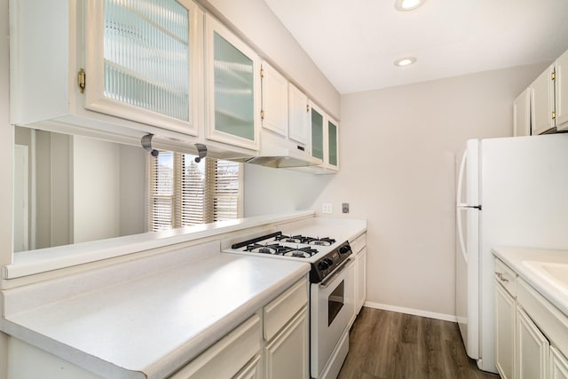 kitchen featuring white fridge, dark hardwood / wood-style flooring, range with gas cooktop, and white cabinets