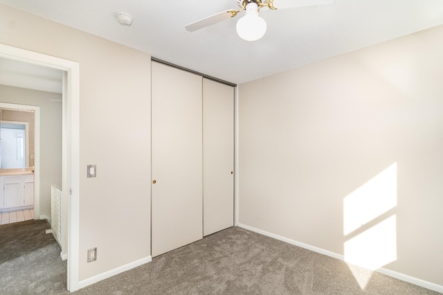 unfurnished bedroom with ceiling fan, light colored carpet, and a closet