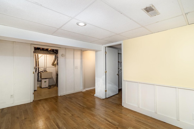 basement featuring hardwood / wood-style floors and a drop ceiling