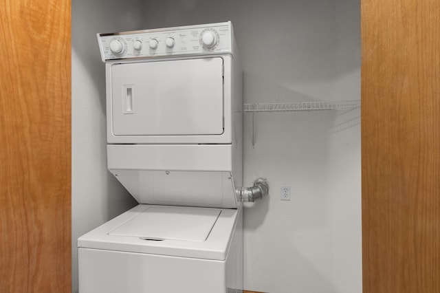 clothes washing area featuring stacked washer and clothes dryer