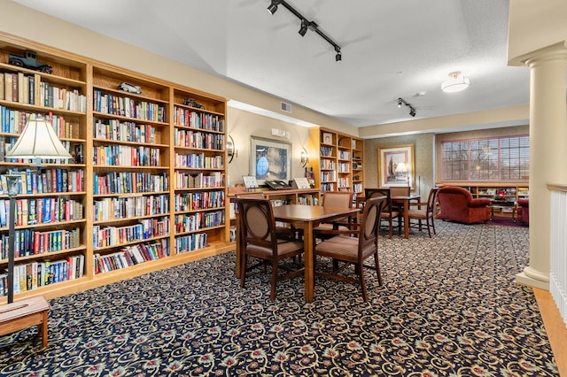 dining space featuring decorative columns, carpet flooring, track lighting, a textured ceiling, and built in shelves