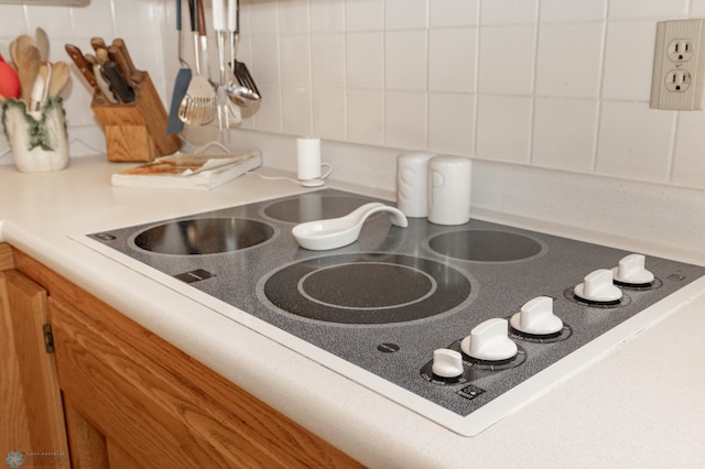 details with tasteful backsplash, white cabinetry, and white electric stovetop