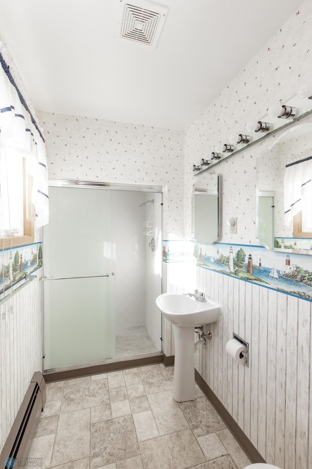 bathroom with baseboard heating and a shower