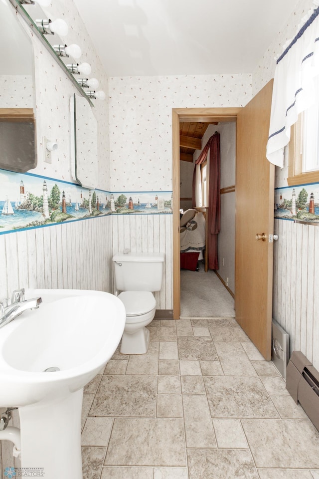 bathroom featuring a baseboard heating unit and toilet