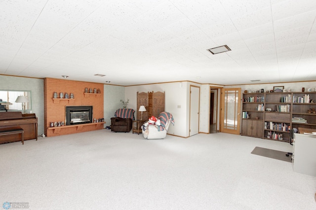 living room featuring carpet floors, crown molding, and a fireplace