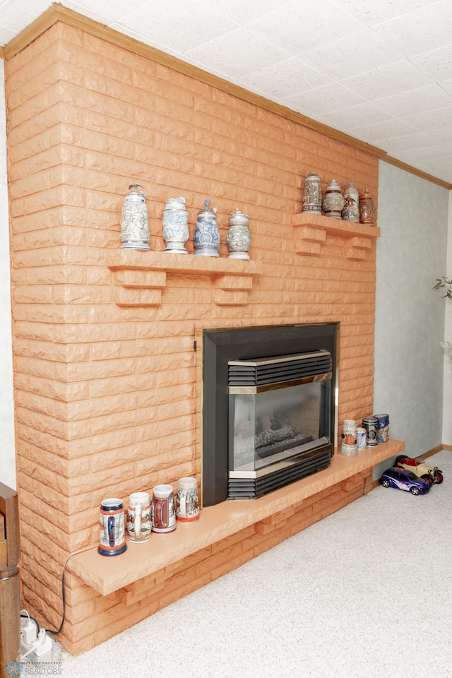 details with a brick fireplace, ornamental molding, and carpet flooring