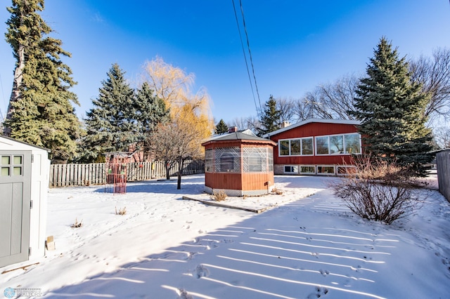 snowy yard featuring a storage shed