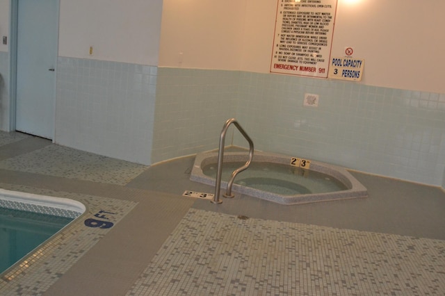 view of swimming pool featuring an indoor hot tub