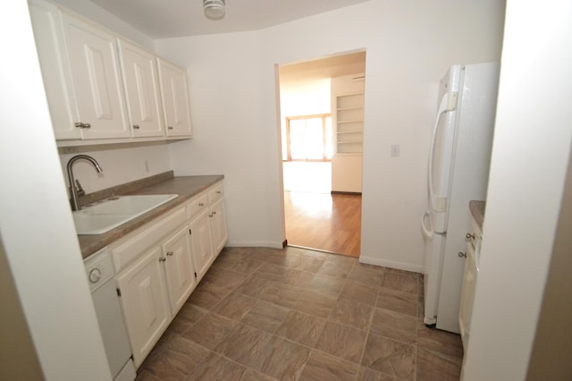 kitchen featuring white cabinetry, sink, and white appliances