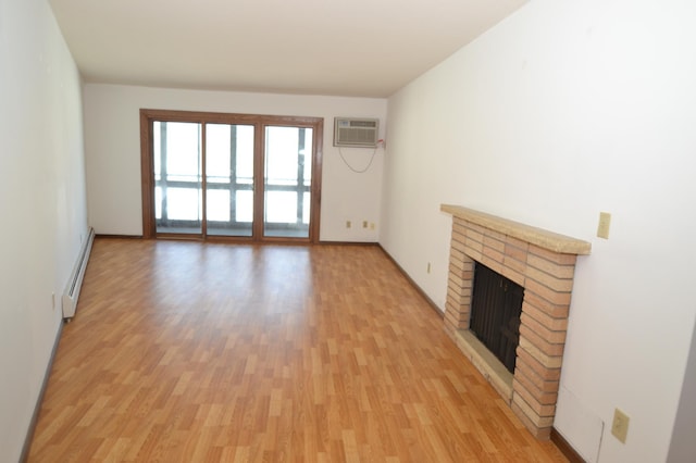 unfurnished living room featuring light hardwood / wood-style flooring, a wall mounted air conditioner, a baseboard radiator, and a fireplace