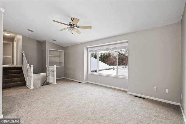 unfurnished room with lofted ceiling, a textured ceiling, ceiling fan, and carpet