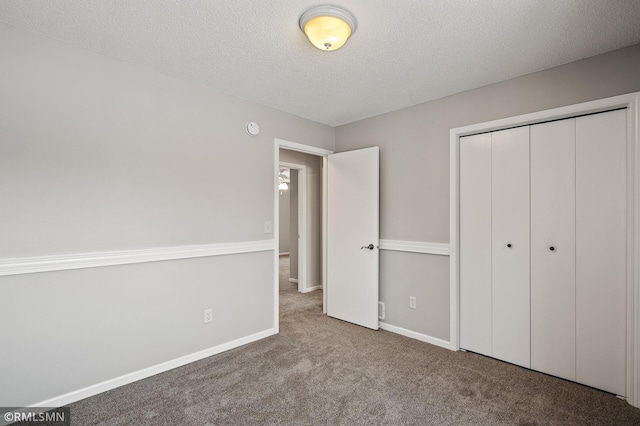 unfurnished bedroom featuring a closet, light carpet, and a textured ceiling