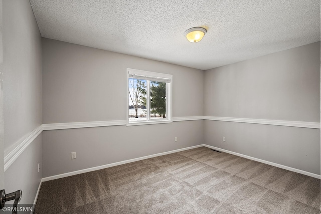 carpeted spare room featuring a textured ceiling