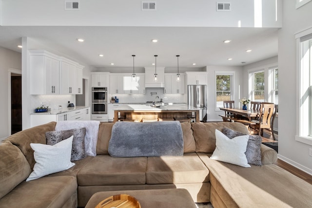 living room with sink and light hardwood / wood-style flooring