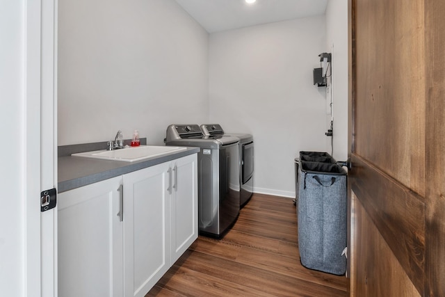 washroom featuring cabinets, washer and clothes dryer, sink, and dark hardwood / wood-style floors