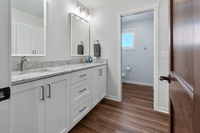 bathroom with hardwood / wood-style flooring, vanity, and toilet