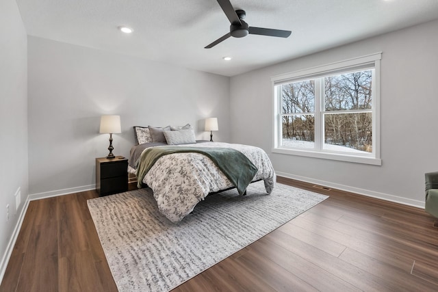 bedroom with dark hardwood / wood-style flooring and ceiling fan