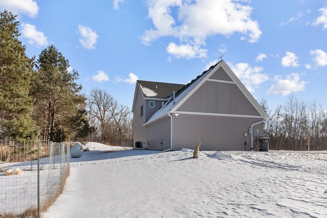 snow covered property with cooling unit