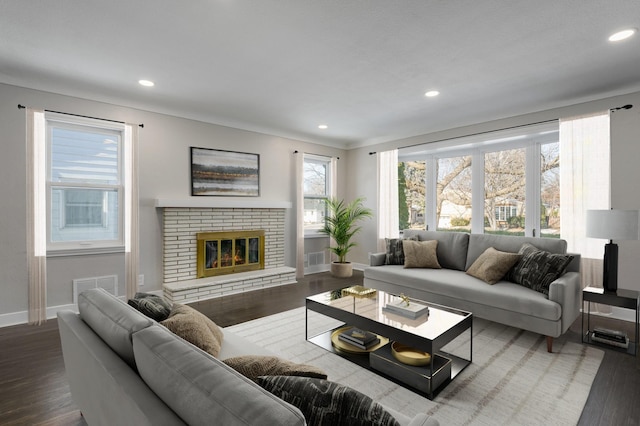 living room featuring a brick fireplace and hardwood / wood-style floors