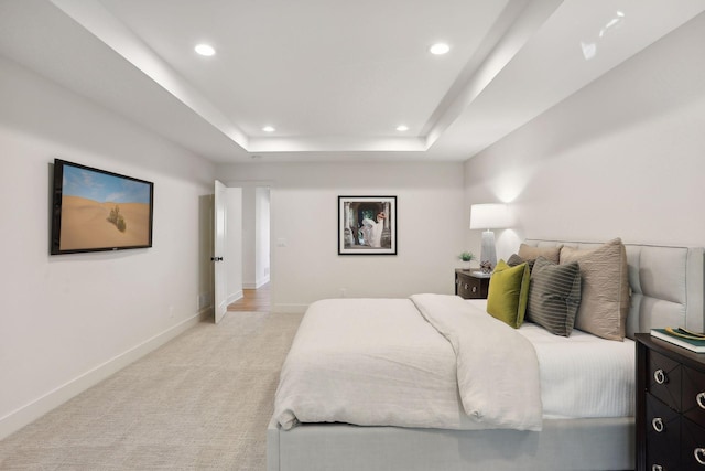 carpeted bedroom with a tray ceiling