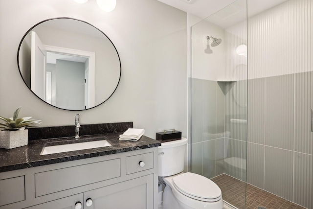 bathroom featuring vanity, a shower with shower door, and toilet