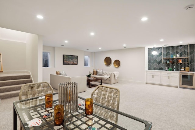 living room with light colored carpet, beverage cooler, and bar area