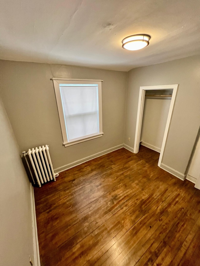 unfurnished bedroom featuring dark wood-type flooring and a closet