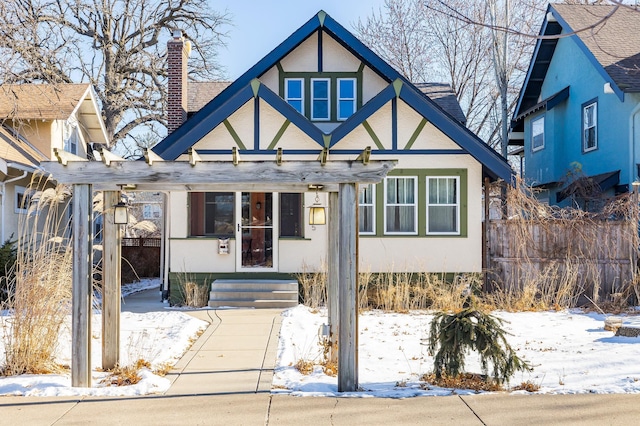 tudor-style house featuring a pergola