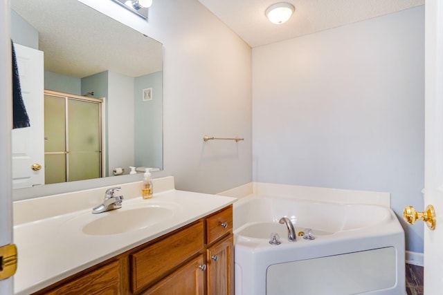 14587 Olivine Way NW, Ramsey, MN 55303 - full bath featuring a stall shower, vanity, a bath, and a textured ceiling