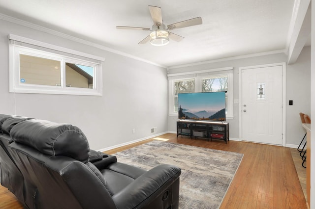 living area featuring a ceiling fan, wood finished floors, baseboards, and ornamental molding