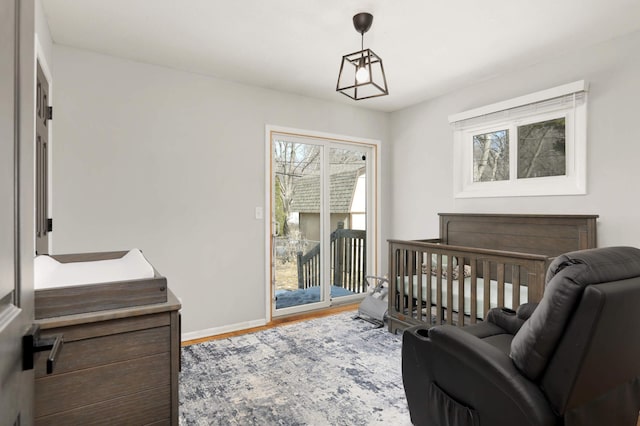 bedroom featuring access to outside, baseboards, and wood finished floors