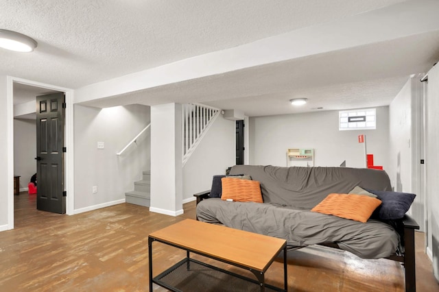 living room with stairway, wood finished floors, baseboards, and a textured ceiling