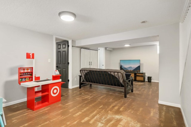 bedroom with a textured ceiling, baseboards, and wood finished floors