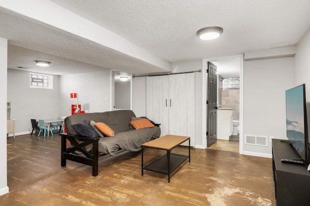 living area with visible vents, concrete floors, and a textured ceiling