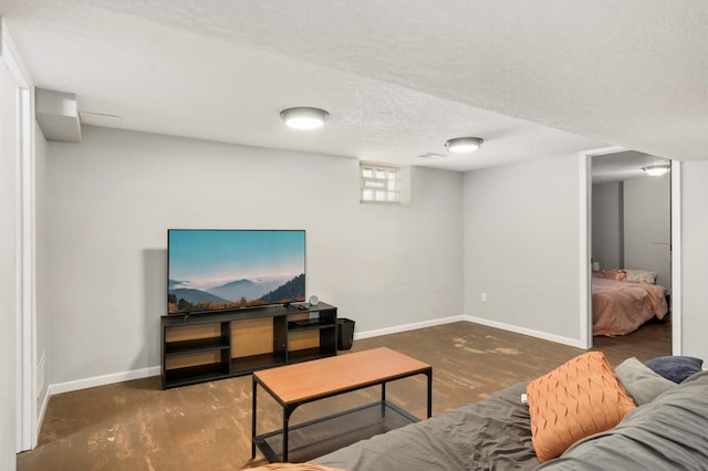 living area with baseboards, a textured ceiling, and concrete flooring