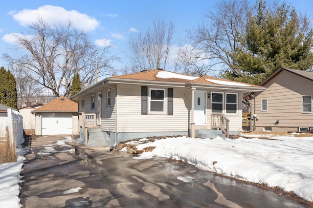 view of front of property featuring a detached garage, an outbuilding, and fence