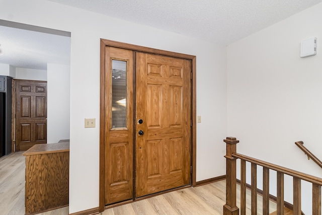 entrance foyer with light hardwood / wood-style flooring and a textured ceiling