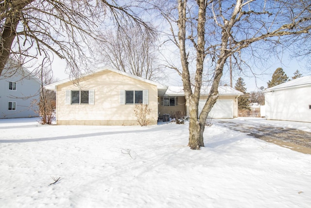 view of front of home with a garage and cooling unit